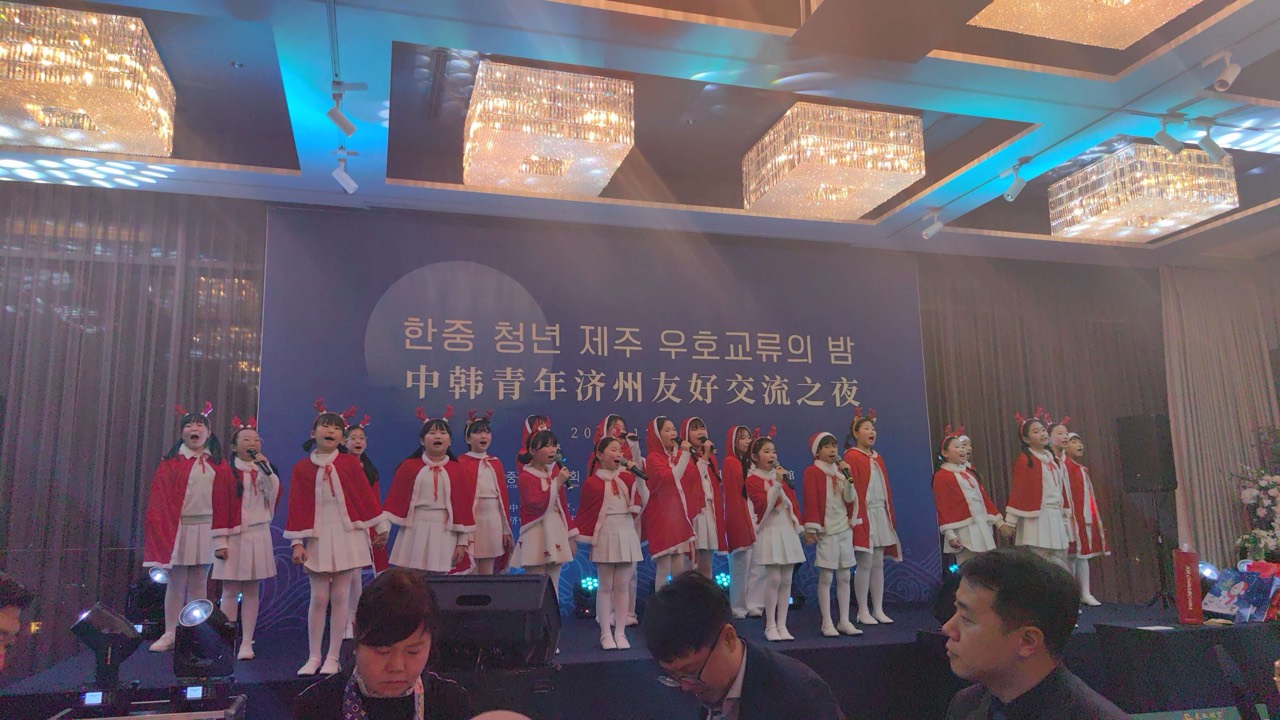 한중 청년 제주 우호교류의 밤 무대에서 빨간 망토와 흰 의상을 입고 노래하는 어린이들